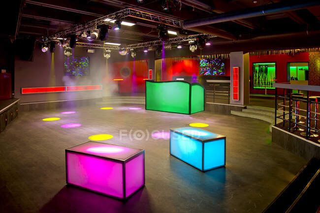 Nachtclub-Interieur, farbenfrohe Beleuchtung, Wandschirme und Leuchtkästen auf der Tanzfläche. — Stockfoto