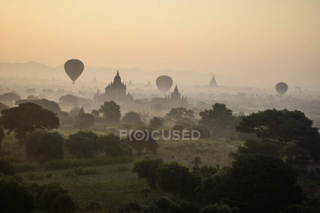 Hot air balloons hovering in the air above the plain of temples in Mandalay — Fotografia de Stock