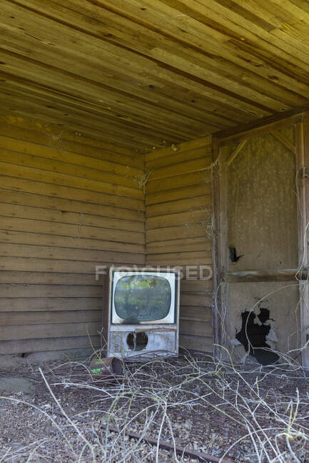 Old TV set on front porch of an abandoned homestead. — Stock Photo