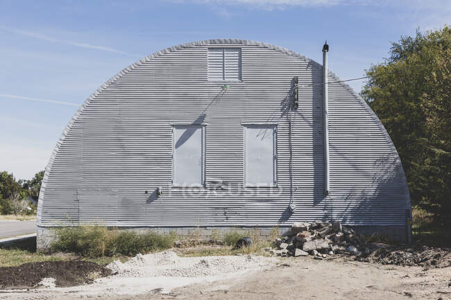 A grey metal barn on a roadside in a small town in Nebraska. — Stock Photo