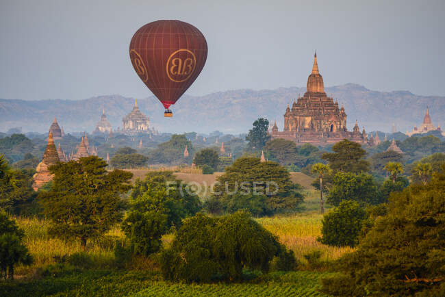 Hot air balloon in the air above a temple in Mandalay. - foto de stock