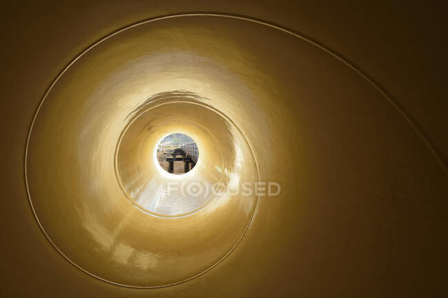 View through a narrow object with a spiral pattern to a street scene. - foto de stock