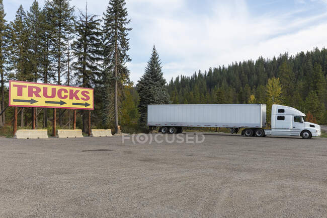 TRUCKS billboard sign and large parked semi truck. — Stock Photo