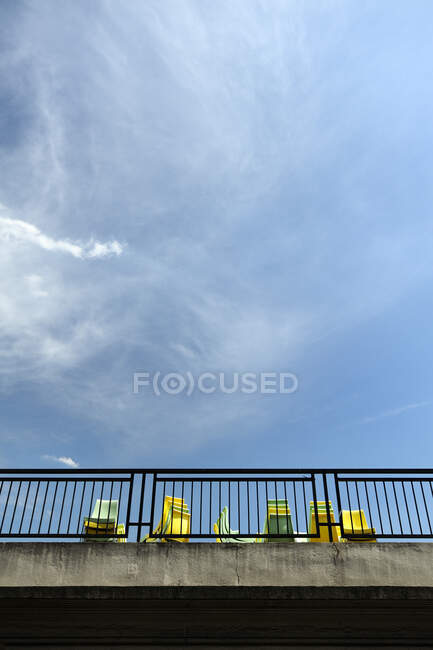 View from below of yellow and blue chairs on a terrace. — Photo de stock