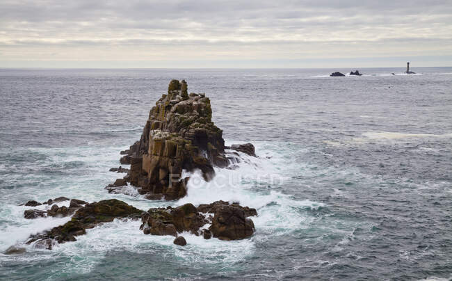 Land's End, isolotti rocciosi al largo, penisola della Penisola, vista su un faro e mare aperto. — Foto stock