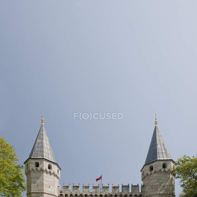 El Harén en el Palacio Topkapi en Estambul, un edificio del siglo XV, dos torres y almenas apuntadas contra un cielo despejado. - foto de stock