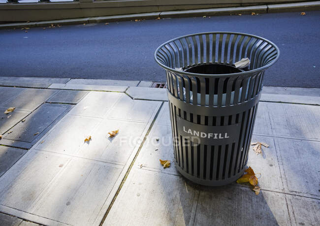 A garbage can on the sidewalk in the city. — Stock Photo