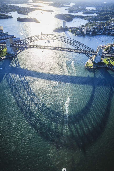 El puente del puerto de Sydney, la sombra del arco sobre el agua, y la vista aérea del paisaje. - foto de stock
