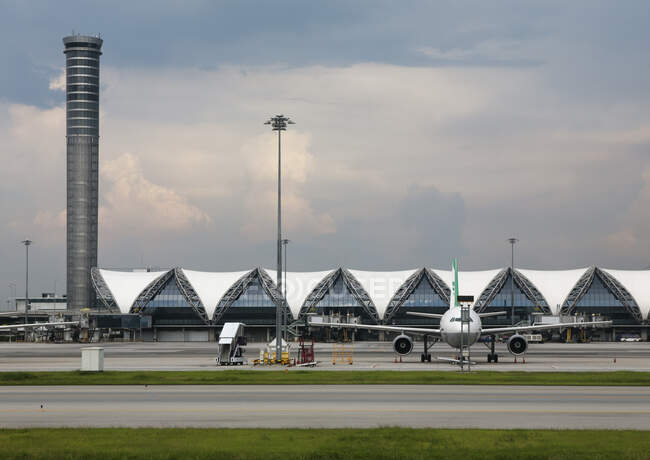 Blick auf ein modernes Flughafenterminal in Bangkok, einen hohen Tower und Flugzeuge. — Stockfoto