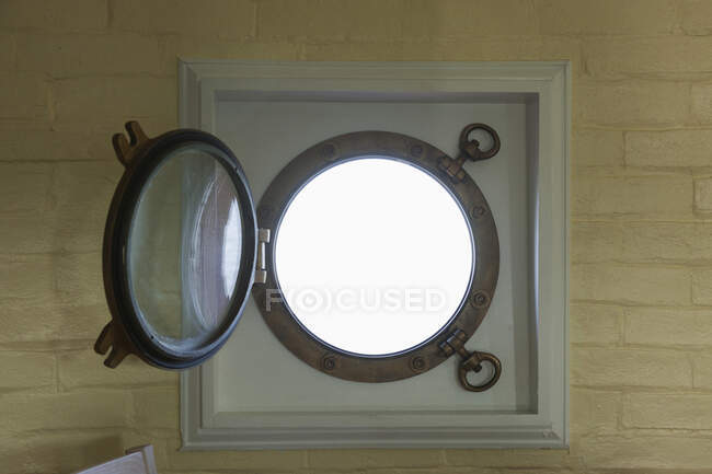 Une fenêtre ronde, un cadre métallique et un hublot en verre rond, ouvert. — Photo de stock