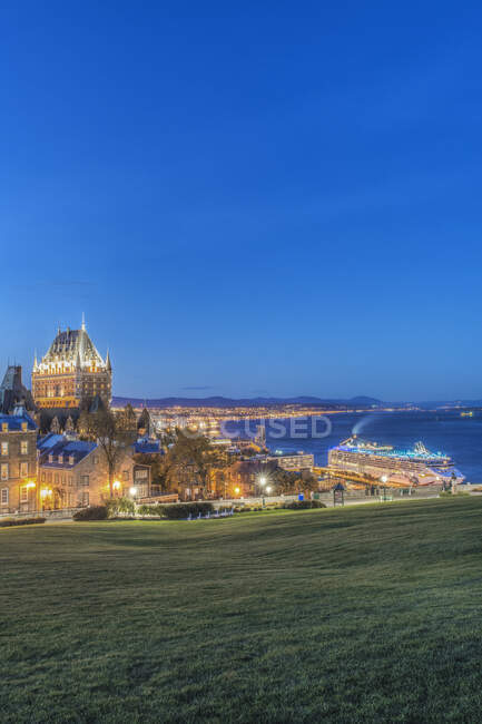 Chateau Frontenac, iluminado por la noche en la ciudad de Quebec, vista sobre el río San Lorenzo. - foto de stock