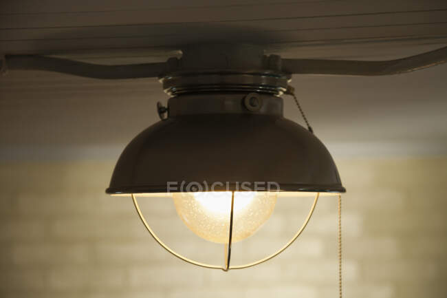 Uma luz de teto com um abajur branco, uma sombra de vidro e uma lâmpada. — Fotografia de Stock