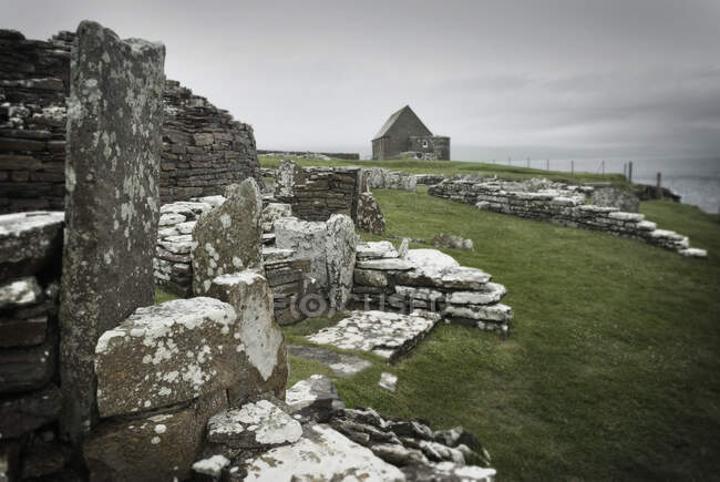 Antiguas casas y piedras en la Broca de Gurness, un asentamiento de la Edad de Hierro en Orcadas. - foto de stock