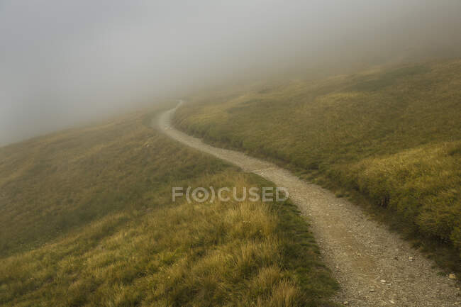 Un sentier de montagne, qui s'avance, à travers les nuages bas et la brume dans les Alpes près de Trient et du Mont Blanc. — Photo de stock