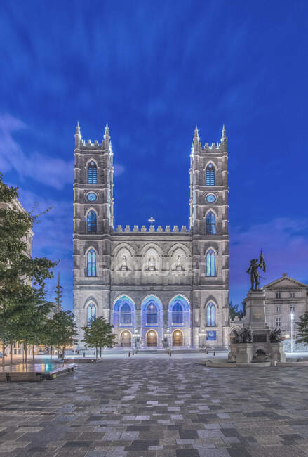 The Notre Dame Basilica, lit up at dusk in the city square in the Old Town of Montreal. — Stock Photo