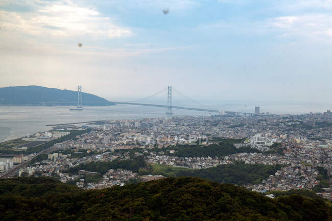 View over the city of Kobe and Akashi Kaikyo Bridge suspension bridge, linking Honshu to Iwaya. - foto de stock