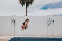 Menina pulando em uma piscina — Fotografia de Stock
