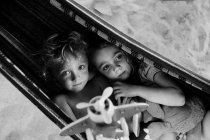 Children playing with airplane in hammock — Stock Photo