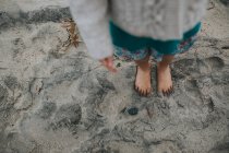 Füße eines Mädchens an einem Sandstrand — Stockfoto