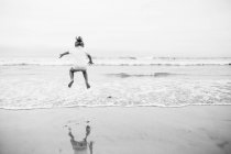 Menina feliz pulando no mar — Fotografia de Stock