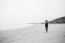 Rapaz a olhar para o mar na praia — Fotografia de Stock