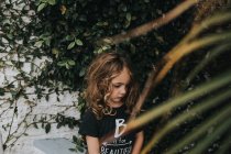 Chica con el pelo rizado en el jardín - foto de stock