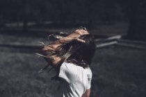 Petite fille aux cheveux ébouriffés par le vent — Photo de stock