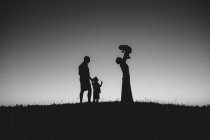 Família com crianças caminhando em campo — Fotografia de Stock