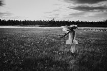 Девушка в белом платье прыгает по полю — стоковое фото