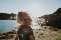 Petite fille aux cheveux ébouriffés par le vent — Photo de stock