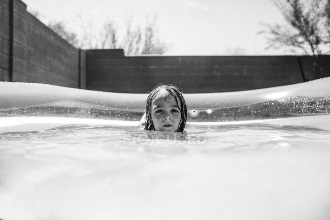 Menina desfrutando de água na piscina — Fotografia de Stock