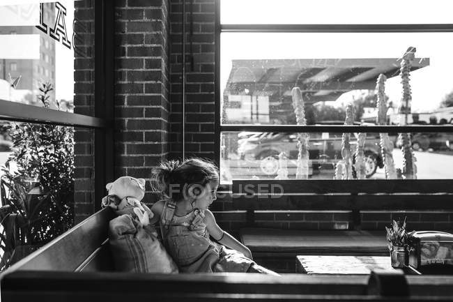 Маленькая девочка сидит в кафе — стоковое фото