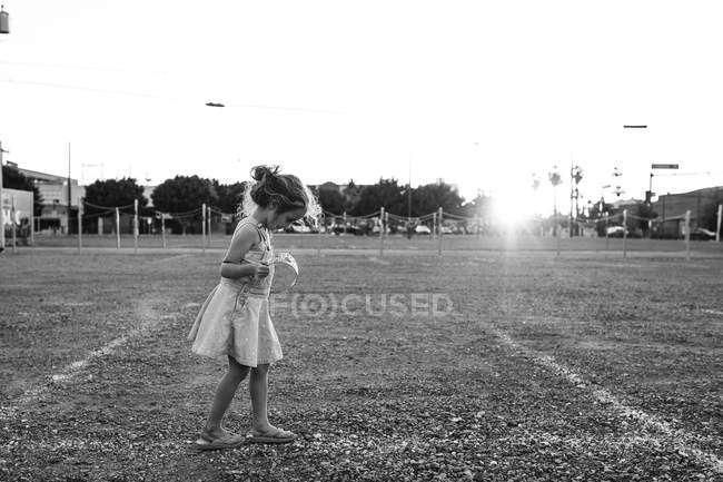 Chica joven en vestido caminando en el campo - foto de stock