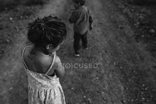 Niños caminando por carretera rural - foto de stock