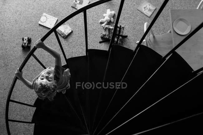 Boy standing on spiral stairs — Stock Photo