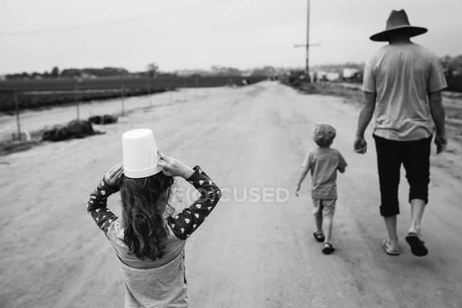 Отец с детьми ходит по сельской дороге — стоковое фото