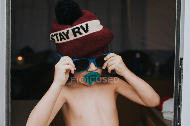 Menino usando chapéu de malha e óculos de sol — Fotografia de Stock