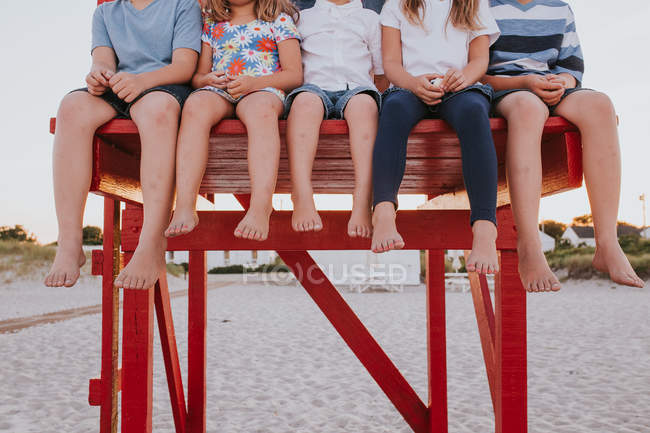 Niños sentados en la torre de salvavidas - foto de stock