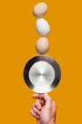 Eggs balancing on pan — Stock Photo