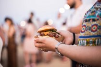 Hamburger in mani femminili — Foto stock
