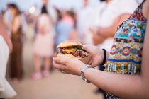 Hamburger dans les mains féminines — Photo de stock