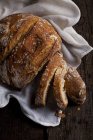 Буханка нарезанного хлеба на белой ткани — стоковое фото