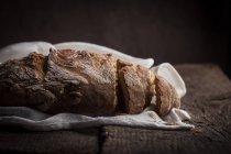 Буханка нарезанного хлеба на белой ткани — стоковое фото