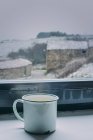 Taza de café en alféizar de la ventana - foto de stock