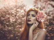 Рудоволоса жінка з квітами у волоссі — стокове фото