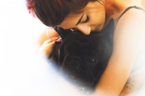 Mulher abraços bulldog raça cão preto — Fotografia de Stock