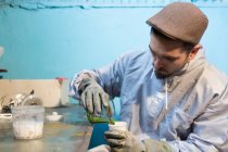 Craftsman pouring green color — Stock Photo