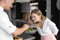 Женщина нюхает еду на сковородке — стоковое фото
