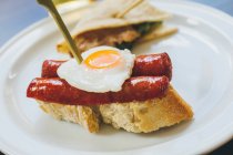Fried egg with sausages on bread — Stock Photo