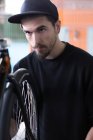 Hombre mirando rueda de bicicleta - foto de stock